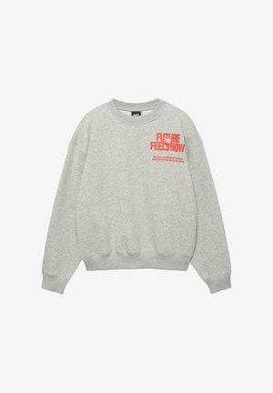 Hellgraues Sweatshirt mit Rundhalsausschnitt, rotem Schriftzug "FUTURE FEELS NOW" und kleinem Slogan auf der linken Brust, langen Ärmeln, gerippten Bündchen und Saum.