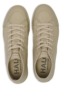 Beżowe trampki z kanwy z gumowym noskiem, okrągłymi sznurówkami i teksturowaną powierzchnią. Wewnątrz znajdują się nadruki marki oraz wyściółka amortyzująca.