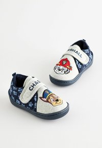 Blaue und graue Kinderschuhe mit Klettverschlüssen. Mit Cartoon-Hundes Designs und Pfotenabdruckmustern auf dem Stoff. Weiches Material, flaches Design.