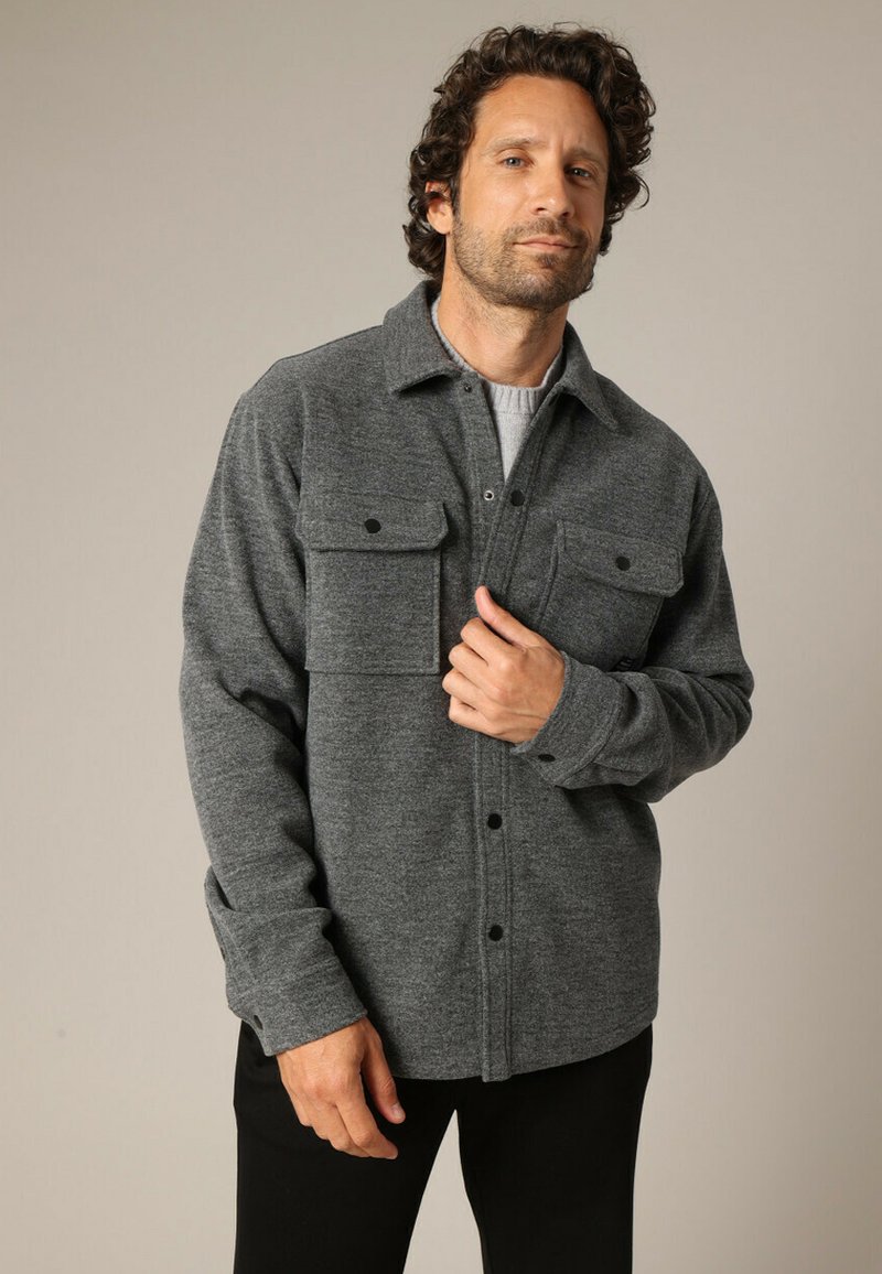 Grijze flanellen overhemdjack met knoopsluiting, twee borstzakken en lange mouwen, met een zachte textuur en een relaxed fit.