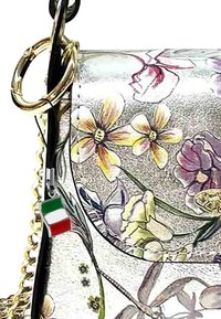 Tasje met bloemenpatroon in gestructureerd zilver materiaal, met een ring van gouden hardware en een charme met de Italiaanse vlag.