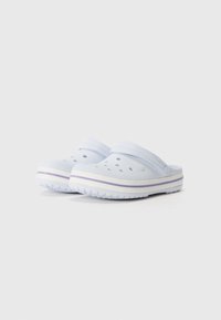 Light blue clogs with perforations for ventilation, a wide strap across the top, and a white sole featuring a purple accent stripe.