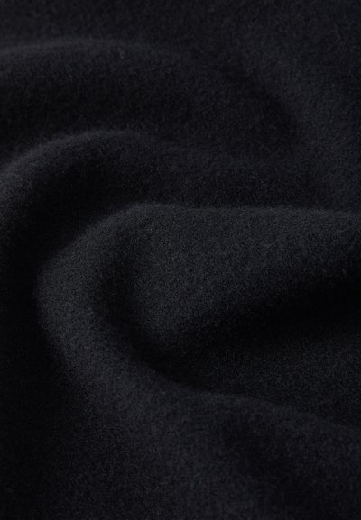 Tecido de lã preta suave, com dobras subtis e detalhes de textura, exibindo uma superfície de material quente e confortável.