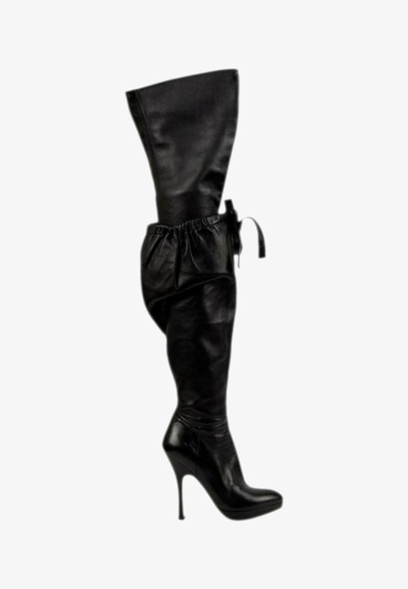 Botte noire en cuir haute jusqu’à la cuisse avec bout pointu, talon haut et bride réglable en haut.