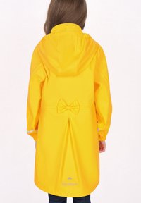 Cappotto impermeabile giallo con cappuccio, dettaglio a fiocco in vita, pieghe nella parte posteriore e rifiniture riflettenti sulle maniche.