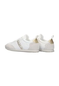 Weiße Sneakers mit hellbeigen Akzenten; glattes Material, Gummisohle und ein Logo an der Seite; runde Zehenform und kontrastierende Texturen.