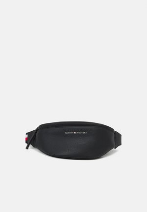 Črna usnjena fanny pack torbica z teksturirano površino, zadrgo in blagovno znamko. Ima rdeče, bele in modre poudarke na naramnicah.