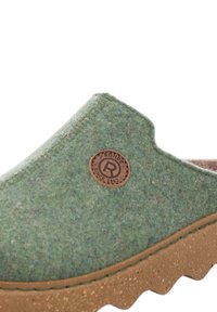 Green felt slipper with a cork-like sole, rounded opening, and circular leather logo patch. Textured material and sturdy design.