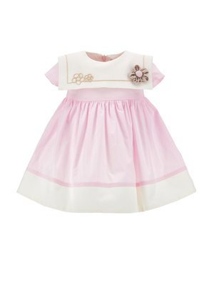 Robe bébé rose à manches courtes avec col blanc, ornement fleur crème et bordure blanche à l'ourlet.