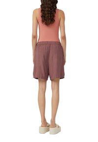 Lichtroze mouwloze top gecombineerd met losse, knielange shorts in gedempt mauve. Elastische tailleband, zachte textuur en minimaal ontwerp.