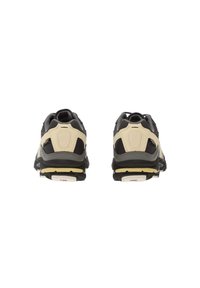 Un paio di scarpe da ginnastica nere, grigie e beige viste da dietro su uno sfondo bianco semplice.