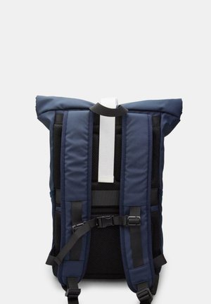 Rucsac din țesătură albastră închisă, cu curele exterioare din plasă căptușită, închidere tip roll-top și curea de accent albă. Dispune de mai multe curele negre ajustabile.