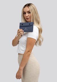 Marineblauw, opvouwbare portemonnee gemaakt van duurzaam materiaal. Voorzien van twee zwarte drukknoopsluitingen en een merklogo op de voorkant. Compact en functioneel ontwerp.