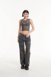 Top corto gris transparente con el texto "Ragged", combinado con jeans rectos de estampado de leopardo azul. Unos zapatos negros gruesos completan el atuendo.