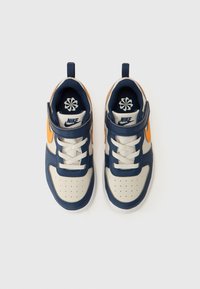 Baskets navy et beige avec des accents orange, en cuir et textile, zone de orteil perforée, sangle Velcro et devant à lacets.
