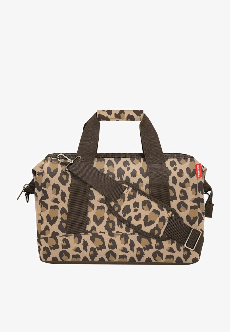 Leopard print duffel bag in tan and brown. Features dual handles, adjustable shoulder strap, and zipper closure. Durable material.