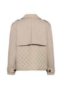 Beige jakke med kviltet nederste rygpanel, knaplukning ved håndleddene og skulderepauleter, vist fra ryggen på en hvid baggrund.