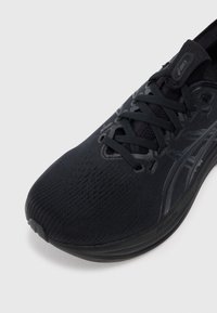 Scarpa da corsa nera con tomaia testurizzata, design con lacci, punta rinforzata e dettagli logo discreti. Presenta una suola in gomma resistente.