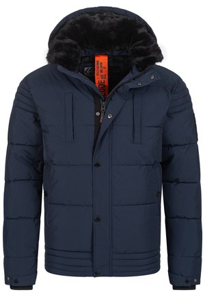 Giacca a vento blu navy con cappuccio foderato in pelliccia sintetica, chiusura con zip e bottoni, tasche frontali e texture trapuntata. Etichetta interna arancione brillante.