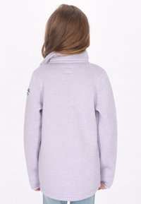 Suéter de color púrpura claro con un cuello alto, mangas largas y corte recto. Presenta una textura suave y un pequeño logo en la manga izquierda.