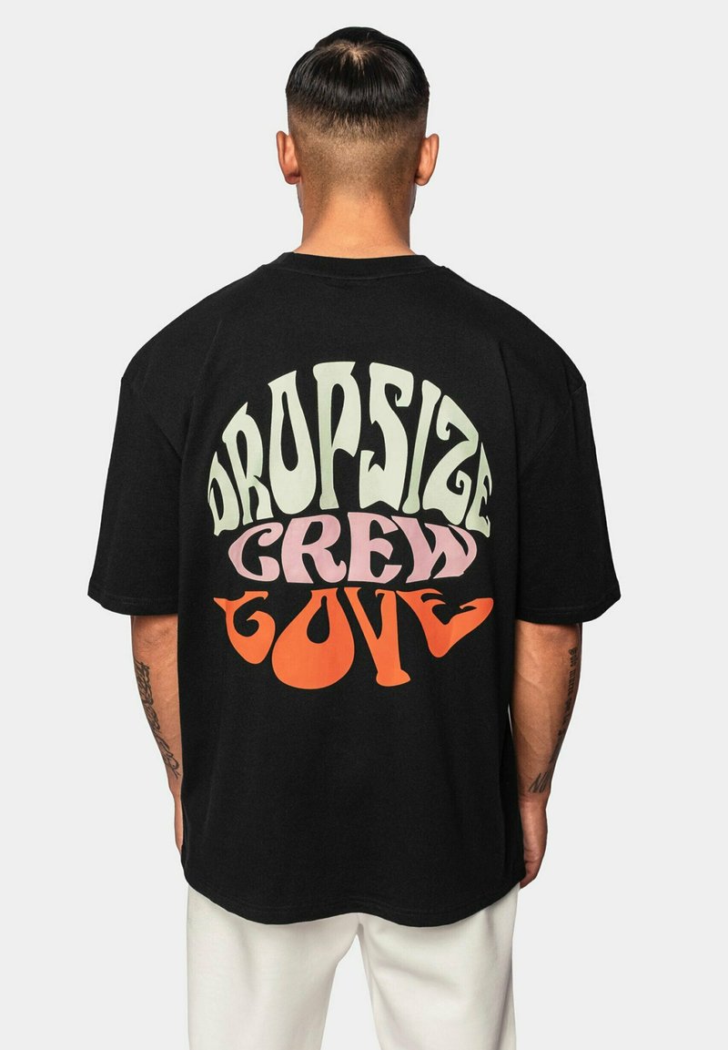 Crna oversized majica s odvažnim, višebojnim natpisom na leđima: "DROPSIZE CREW LOVE" u zelenoj, ružičastoj i narančastoj boji. Pamuk.