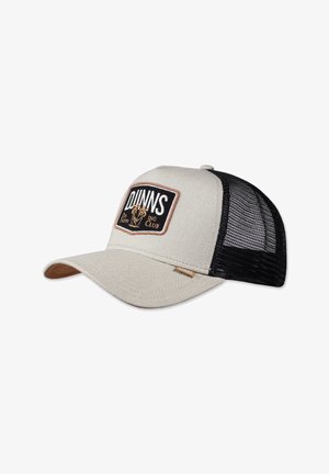 Gorra de rejilla color beige claro con un parche negro que lleva la inscripción "DUNNS" y un gráfico de león, costuras marrones y una visera curva con un acento en tono marrón claro.