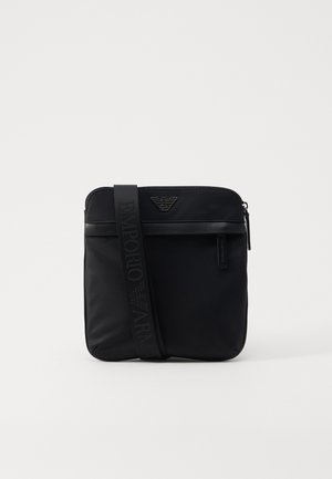 Borsa a tracolla nera realizzata in nylon liscio con chiusura a zip, caratterizzata da un accent logo e una tracolla regolabile con il nome del marchio impresso.