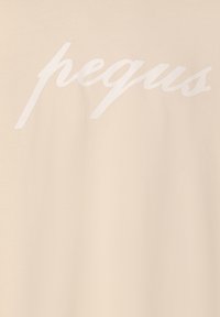 Beige puuvillane T-särk, millel on rindkeres suur valge kaldkirjas tekst "pequs". Sile tekstuur, juhuslik disain ja mugav lõige.