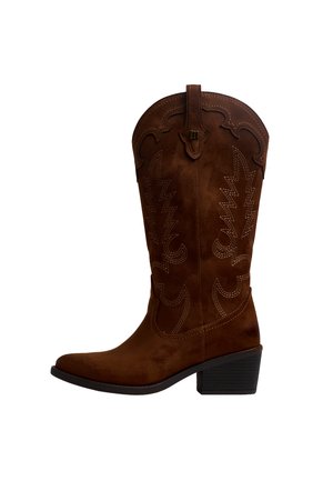 Bota vaquera de ante marrón con costuras decorativas, tacón apilado de altura media y tiradores en la parte superior.