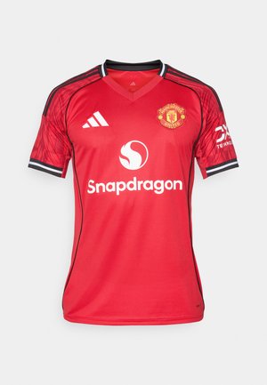 Rød Manchester United-drakt med sorte detaljer, V-halsdesign, Adidas-logo, klubbens emblem og Snapdragon-merke i midten.