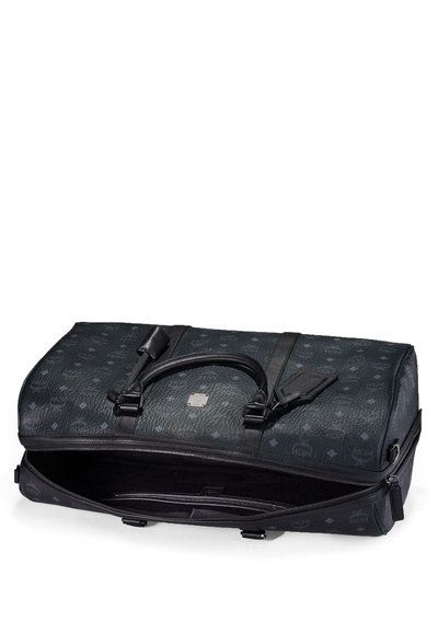 Bolsa de lona de cuero negro con patrones en relieve, asas dobles, etiqueta de equipaje y cremallera superior parcialmente abierta que muestra un interior vacío.