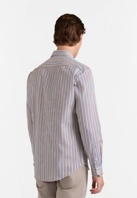 Gestreept longsleeve shirt van lichte stof, met smalle verticale strepen in blauw, rood en wit. Klassieke kraag en knopenmanchetten.