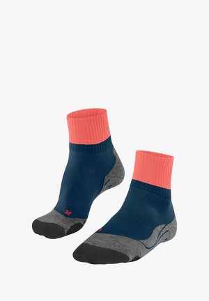 Chaussettes mi-mollet avec un corps bleu marine, un rebord côtelé corail et un talon et une pointe gris. Elles présentent une texture lisse et un détail de marque subtil.