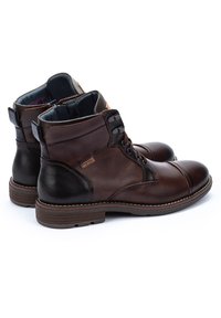 Brown leather ankle boots with a textured panel, rounded toe, and lace-up design. Features contrasting dark accents and a durable sole.