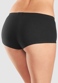 Čierne bavlnené elasťákové šortky s nízkym pásom a hladkým materiálom, s zaobleným lemom a minimálnymi švami pre pohodlie.