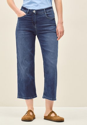 Culottes en denim bleu foncé, avec une taille mi-haute, deux poches avant, des coutures discrètes et une coupe évasée à jambe courte.