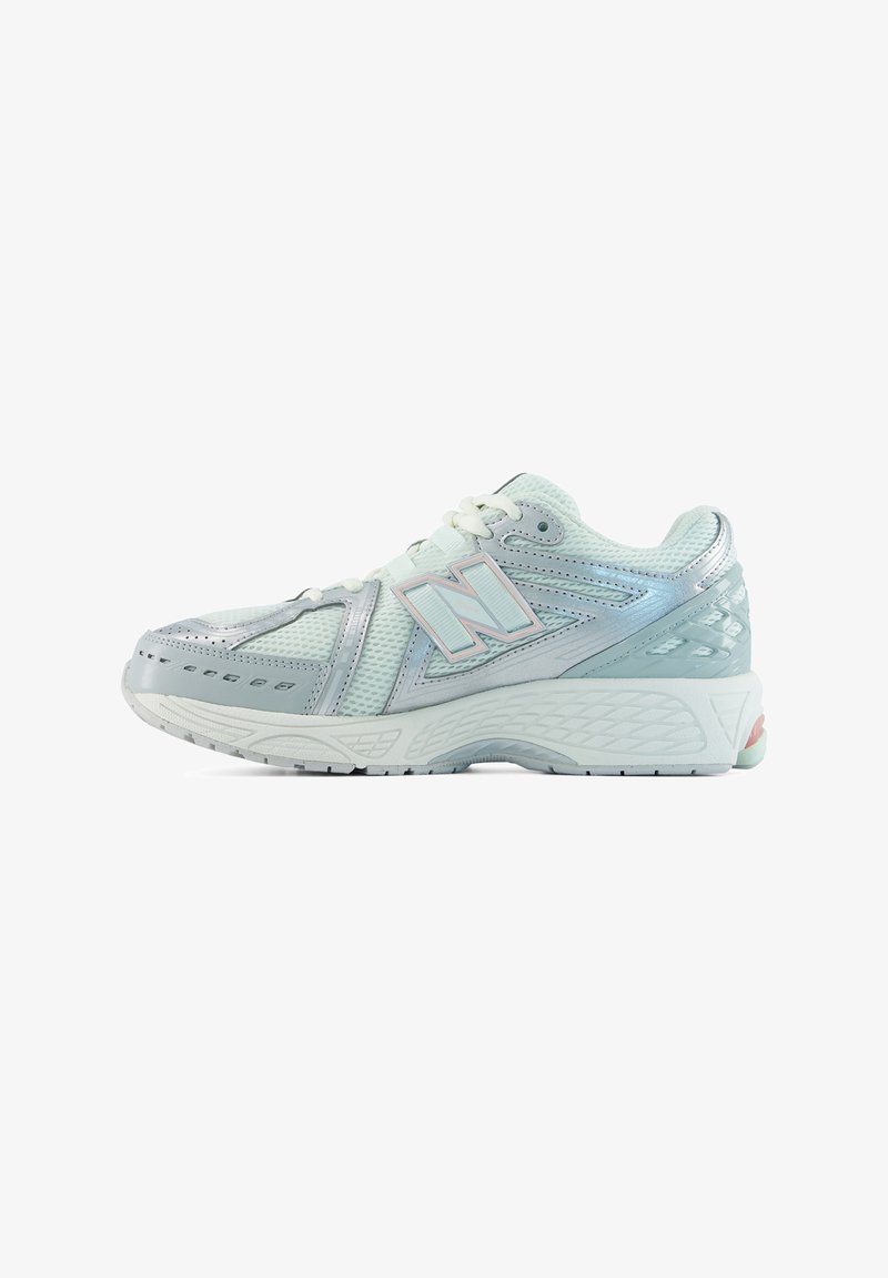 Бяло и сребърно спортно обувка New Balance с мрежест горен слой, закопчаване с връзки и текстурирана подметка, показана в страничен профил.