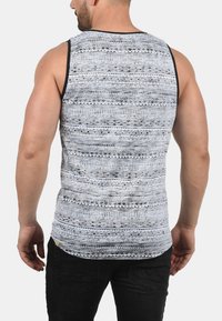 Men's sleeveless tank top in grey with black geometric patterns, featuring a round neckline and contrast black armholes. Cotton blend fabric.