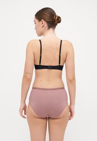 Black adjustable bra with slim straps and a hook closure; pink high-waisted briefs with a smooth texture and subtle logo detail on the back.