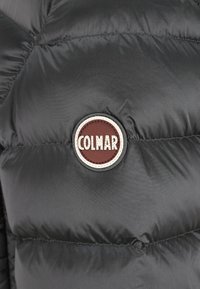 Puffig svart jacka med en rund brun och vit logotypapplikation märkt "COLMAR" framtill, med quiltat mönster och slät tyg.