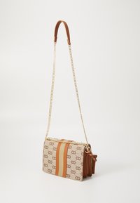 Crossbody bag with a beige canvas body, brown leather accents, a gold chain strap, and a central striped design in tan and cream.