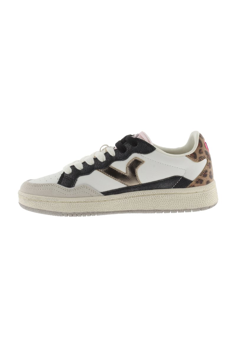 Zapatillas blancas y negras con un logo metálico dorado, detalles de estampado de leopardo texturizado y una suela de goma crema. Cordones y costuras visibles.