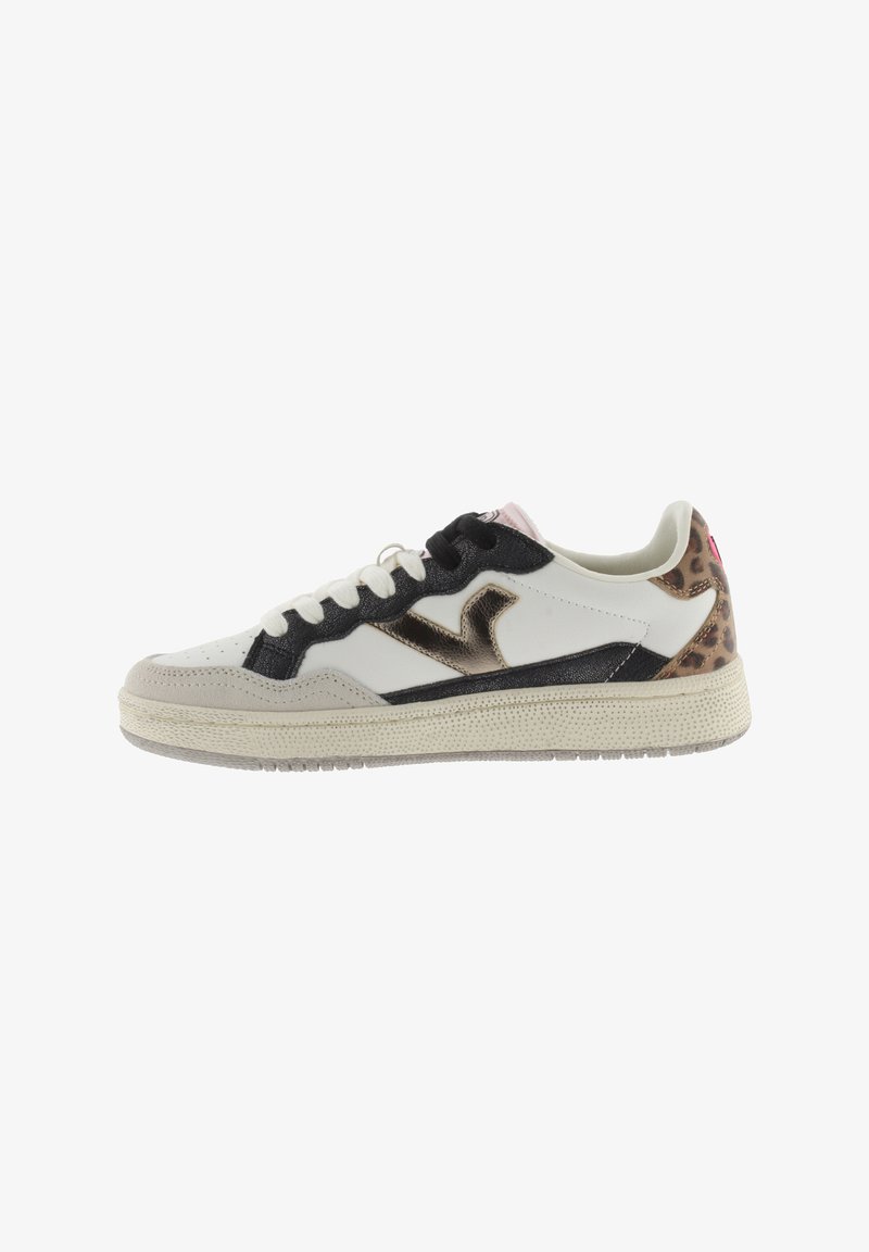 Zapatillas blancas y negras con un logo metálico dorado, detalles de estampado de leopardo texturizado y una suela de goma crema. Cordones y costuras visibles.