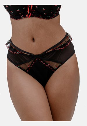 Schwarzes durchsichtiges Dessous-Set mit Kirschstickerei und roten, gewellten Rändern, getragen am Mittelteil und an den Hüften einer Frau vor weißem Hintergrund.