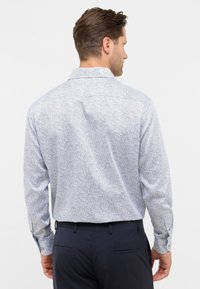 Camicia a maniche lunghe in tessuto azzurro chiaro con motivo paisley. Presenta un colletto botton-down e polsini a un bottone. Vestibilità slim.