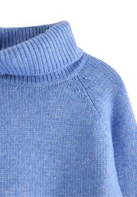 Lysblå strikket turtleneck sweater med ribbet krave og glat strikstruktur på skulder- og brystområdet.