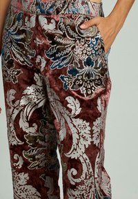 Fluwelen broek in rijk bordeauxrood met ingewikkelde zilveren en blauwe bloemmotieven; heeft een ontspannen pasvorm en zijzakken voor praktisch gebruik.