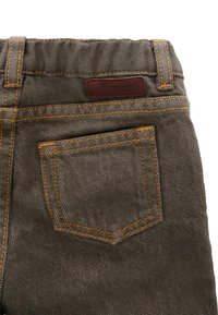 Pantaloni in denim grigio con cuciture arancioni, dotati di una tasca posteriore e di un'etichetta in pelle marrone con il marchio sulla vita. Include una vita elasticizzata.
