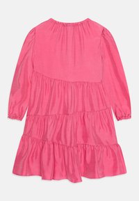 Rosa langärmliges Kleid mit gerafftem Ausschnitt, gestufter Rüschendesign und weicher Textur, mit elastischen Manschetten und fließender Silhouette.