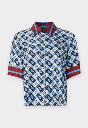 Kurzarmhemd mit einem blauen, schwarzen und weißen geometrischen Muster. Rote Akzente an Kragen und Ärmeln. Aus glattem Stoff mit Knöpfen gefertigt.